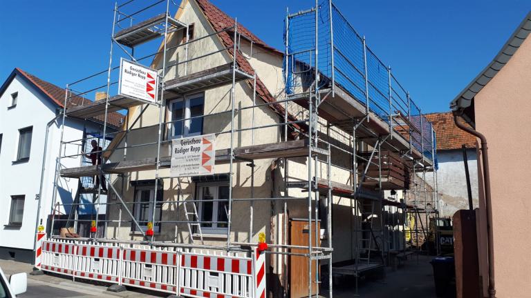 Ein Wohnhaus ist rundum von einem Baugerüst für Renovierungsarbeiten umgeben.